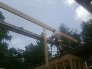 Carpenter setting a ridge beam over a new addition frame — Ice Dam Removal by Roofing Brothers in Wallace