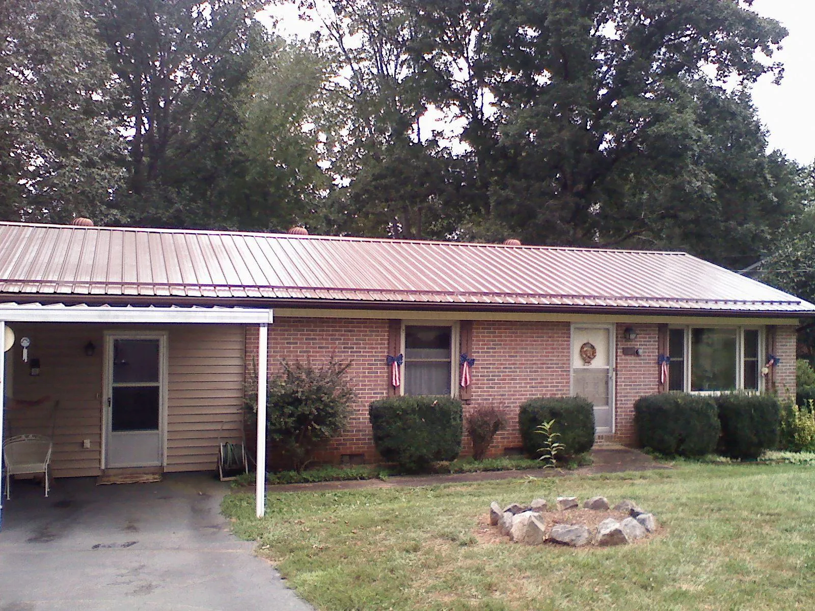 Bronze metal roof and carport on a brick ranch home — Roof Repair work by our crew in Wallace