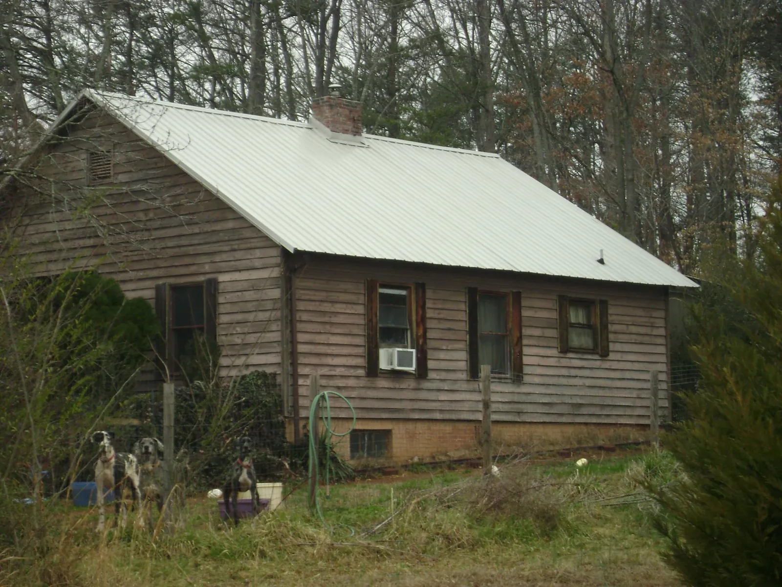 White metal roof on an old wood sided farmhouse, from a Metal Roof Installation job in Wallace